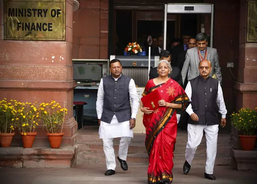 Indian Finance Minister Nirmala Sitharaman, in red, leaves her office for President's house before presenting the federal budget for the financial year 2023-24 in the Parliament in New Delhi, India, Wednesday, Feb. 1 2023. (AP Photo/Manish Swarup)