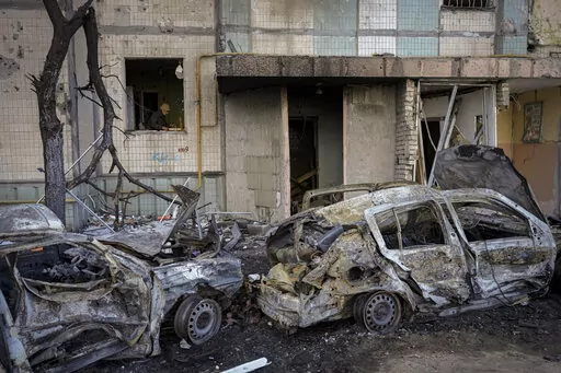 A woman cleans up her kitchen from debris in an apartment block damaged by a bombing the previous day in Kyiv, Ukraine, Monday, March 21, 2022. As Russia intensified its effort to pound Mariupol into submission, its ground offensive in other parts of Ukraine has become bogged down. Western officials and analysts say the conflict is turning into a grinding war of attrition, with Russia bombarding cities. (AP Photo/Vadim Ghirda)