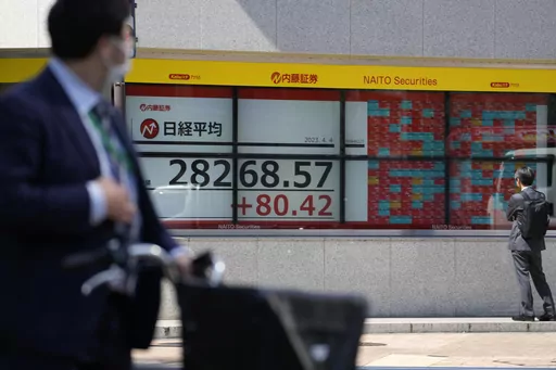 People look at an electronic stock board showing Japan's Nikkei 225 index at a securities firm Tuesday, April 4, 2023 in Tokyo. (AP Photo/Shuji Kajiyama)