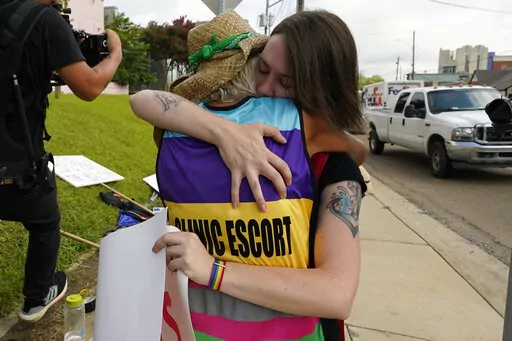 Derenda Hancock, co-director of the Jackson Women's Health Organization clinic patient escorts, better known as the Pink House defenders, left, hugs a tearful abortion rights supporter Sonnie Bane, outside the Jackson Women's Health Organization clinic in Jackson, Miss., Wednesday, July 6, 2022. The clinic is the only facility that performs abortions in the state. However, on Tuesday, a chancery judge rejected a request by the clinic to temporarily block a state law banning most abortions. Witho