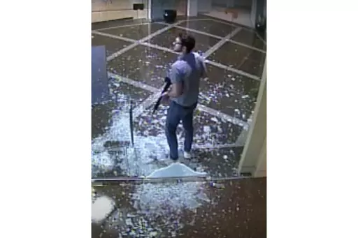 This image taken from surveillance video provided by the Louisville Metro Police Department shows bank employee Connor Sturgeon, 25, carrying an AR-15 assault-style rifle after opening fire at Old National Bank, in Louisville, Ky., Monday, April 10, 2023. Sturgeon, a man who opened fire at a Louisville bank, killing five co-workers, had confronted mental health problems over the last year and the situation appeared to be managed until just days before the shooting, his mother said. (Courtesy of 