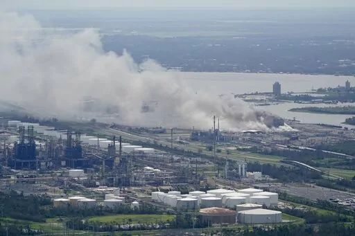 A chemical fire burns at a facility during the aftermath of Hurricane Laura, Aug. 27, 2020, near Lake Charles, La. The Securities and Exchange Commission moved closer Friday, June 17, 2022, to a final rule that would dramatically change what public companies tell shareholders about climate change. Companies would also have to disclose risks related to the physical impact of storms, drought and higher temperatures brought on by global warming.  (AP Photo/David J. Phillip, File)