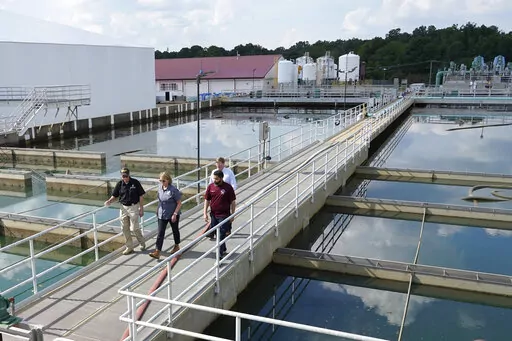 Jim Craig, with the Mississippi State Department of Health, left, leads Jackson Mayor Chokwe Antar Lumumba, right, Deanne Criswell, administrator of the Federal Emergency Management Agency (FEMA), center, and Mississippi Gov. Tate Reeves, rear, as they walk past sedimentation basins at the City of Jackson's O.B. Curtis Water Treatment Facility in Ridgeland, Miss., Friday, Sept. 2, 2022. Jackson's water system partially failed following flooding and heavy rainfall that exacerbated longstanding pr