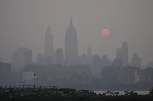 The sun rises over a hazy New York City skyline as seen from Jersey City, N.J., Wednesday, June 7, 2023. (AP Photo/Seth Wenig)