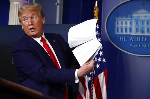 President Donald Trump holds up papers as he speaks about the coronavirus in the James Brady Press Briefing Room of the White House on April 20, 2020, in Washington. Revelations of a roughly eight-hour gap in official records of then-President Donald Trump's phone calls on the day of last year's insurrection at the U.S. Capitol are raising fresh questions about the diligence — or lack thereof — of the White House's record-keeping. (AP Photo/Alex Brandon, File)