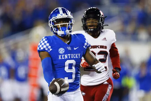 Kentucky wide receiver Tayvion Robinson (9) runs the ball into the end zone for a touchdown while being chased by Northern Illinois cornerback Cyrus McGarrell (22) during the second half of an NCAA college football game in Lexington, Ky., Saturday, Sept. 24, 2022. (AP Photo/Michael Clubb)
