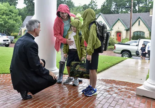 The Rev. Joseph Strickland, left, bishop of the Diocese of Tyler, goes to one knee Wednesday, Aug. 17, 2016, to greet children on the first day of school at St. Gregory Cathedral School in Tyler, Texas. Pope Francis on Saturday, Nov. 11, 2023, forcibly removed Strickland, a firebrand conservative prelate active on social media who has been a fierce critic of the pontiff and has come to symbolize the polarization within the U.S. Catholic hierarchy. (Andrew D. Brosig/Tyler Morning Telegraph via AP