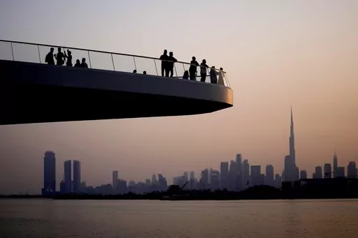 People stand on the observation deck of the Dubai Creek Harbour in Dubai, United Arab Emirates, Sunday, June 18, 2023, to view the city skyline with the world's tallest tower, the Burj Khalifa. Dubai hosts the United Nations COP28 climate talks starting Nov. 30. (AP Photo/Kamran Jebreili, File)