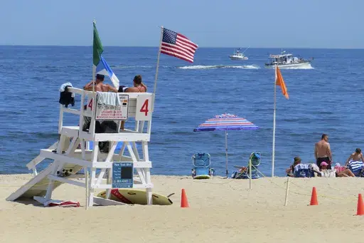 A boat passes by July 2, 2024, off Sea Girt, N.J., where a power cable from the Atlantic Shores offshore wind farm project is projected to come ashore. (AP Photo/Wayne Parry, File)