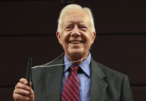 Former U.S. President Jimmy Carter poses for photographers with a water pipe filter, that is used to combat guinea worm disease, during a news conference to mark the launch of a campaign to eradicate the disease in central London, Wednesday, Oct. 5, 2011. (AP Photo/Lefteris Pitarakis, File)