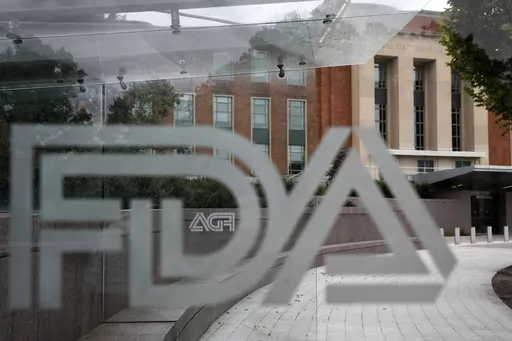 A U.S. Food and Drug Administration building is seen behind FDA logos at a bus stop on the agency's campus in Silver Spring, Md., on Aug. 2, 2018. Federal health advisers voted against an experimental treatment for Lou Gehrig’s disease at a Wednesday, Sept. 27, 2023, meeting prompted by years of patient efforts seeking access to the unproven therapy. (AP Photo/Jacquelyn Martin, File)