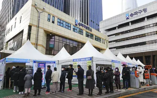 People wait for their coronavirus test at a testing station in Seoul, South Korea, Tuesday, Feb. 15, 2022. (Kwon Chang-hee/Newsis via AP)