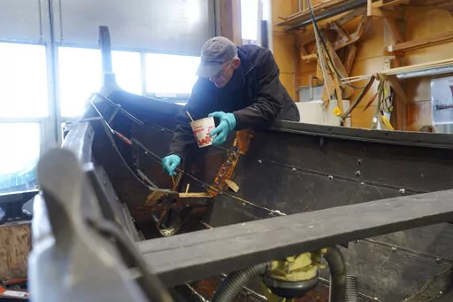 A man repairs a 10-meter wooden row boat, built in the Nordic clinker boat tradition, at the Viking Ship Museum's boatyard. Roskilde, Denmark, Monday, Jan. 17, 2022.  For thousands of years, wooden sail boats, best known for having been in use during the Viking-era, allowed the peoples of northern Europe to spread trade, influence and -- in some cases war — across the seas and rivers. In December, UNESCO, the U.N.’s culture agency, added the “clinker’ boat traditions to its list of “In