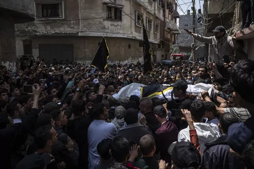 Mourners carry the bodies of Khalil Bahtini, the Islamic Jihad militant group's commander for the northern Gaza Strip, his wife and son, who were killed in an Israeli airstrike at their family home, during their funeral, in Gaza City, Tuesday, May 9, 2023. Bahtini was among three senior Islamic Jihad commanders killed in targeted airstrikes early Tuesday. Palestinian health officials said at least 10 others were killed, including wives of two of the militants, several of their children and other
