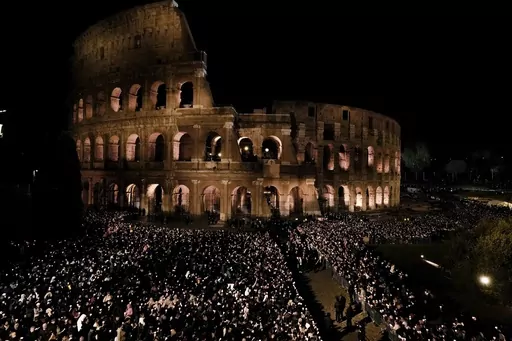 People hold candles during a Via Crucis (Way of the Cross) torchlight procession on Good Friday, in Rome, Friday, April 7, 2023. The Vatican says Pope Francis won't go to the Colosseum for the traditional Good Friday procession but instead he will watch it from his home at the Vatican due to unseasonably cold nighttime temperatures in Rome. (AP Photo/Alessandra Tarantino)