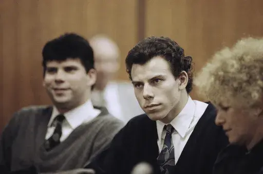 Lyle, left, and Erik Menendez sit with defense attorney Leslie Abramson, right, in the Municipal Court in the Beverly Hills area of Los Angeles, during a hearing, Nov. 26, 1990. (AP Photo/Nick Ut, File)
