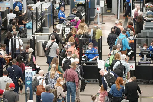 Travelers queue up move through the north security checkpoint in the main terminal of Denver International Airport, Thursday, May 26, 2022, in Denver. Airline travelers are not only facing sticker shock this Memorial Day weekend, the kick off to the summer travel season, but they're also battling a pileup of flight cancellations. More than 1,000 flights were canceled as of Saturday afternoon, May 28, according to flight tracking website FlightAware, after 2,300 cancellations on Friday. (AP Photo