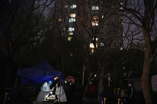 A resident gets swabbed for the COVID test outside a neighborhood in Beijing, Saturday, Nov. 19, 2022. (AP Photo/Ng Han Guan)