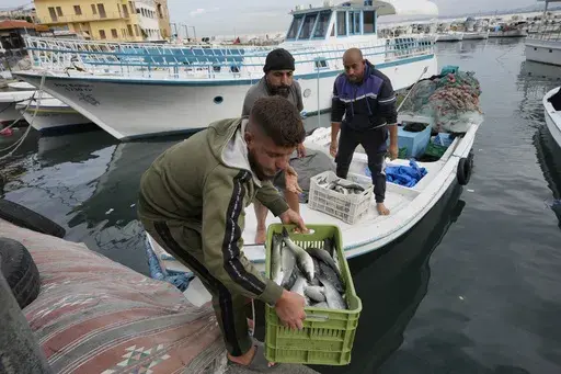 A fisherman holds a basket full of fish in Tyre, southern Lebanon, where the ceasefire between Israel and Hezbollah brought hope for normality back to many on Friday, Nov. 29, 2024. (AP Photo/Hussein Malla)