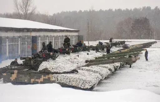 Ukrainian soldiers examine their tanks at a military unit close to Kharkiv, Ukraine, Monday, Jan. 31, 2022. Russia's foreign minister claims that NATO wants to pull Ukraine into the alliance, amid escalating tensions over NATO expansion and fears that Russia is preparing to invade Ukraine. (AP Photo/Andrew Marienko)