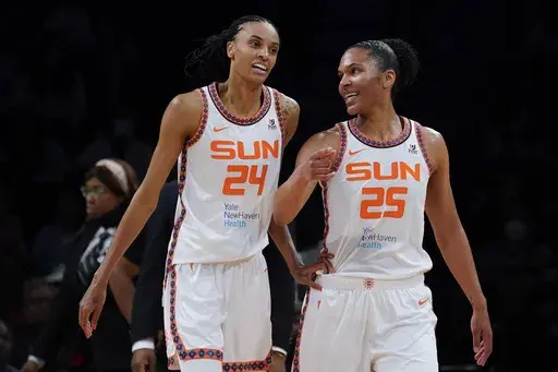 Connecticut Sun forward DeWanna Bonner (24) and forward Alyssa Thomas (25) speak during a time out in the first half during a WNBA basketball game against the New York Liberty, Tuesday, May 17, 2022, in New York. Bonner and Thomas have found a comfortable work-life balance in the WNBA. They are the unquestioned leaders of the Sun on the court and life partners off of it. (AP Photo/John Minchillo, File)