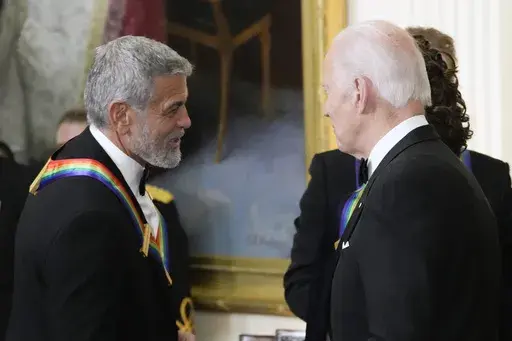 President Joe Biden shakes hands with actor, director and producer George Clooney during the Kennedy Center honorees reception at the White House in Washington, Dec. 4, 2022. Movie star and lifelong Democrat George Clooney is adding his voice to calls for Joe Biden to leave the presidential race. Clooney says in a New York Times opinion piece Wednesday that he loves Biden, but the party would lose the presidential race as well as any control in Congress with him as the nominee. (AP Photo/Manuel 