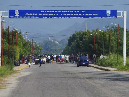 Migrants, mostly from Venezuela, arrive at a camp where Mexican authorities will arrange permits for their continued travel north, in San Pedro Tapanatepec, Oaxaca, Mexico Wednesday, Oct. 5, 2022. As migrants, especially Venezuelans, struggle to come to terms with a new U.S. policy discouraging border crossings, the town of San Pedro Tapanatepec is unexpectedly playing host to over 10,000 migrants camped far from the U.S. border.  (AP Photo/Marco Ugarte)