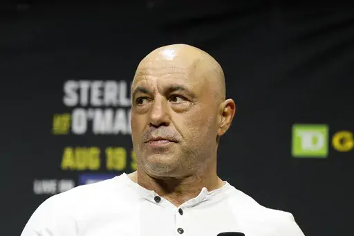 Joe Rogan looks on at the ceremonial weigh-in for the UFC 292 mixed martial arts event, Aug. 18, 2023, in Boston. (AP Photo/Gregory Payan, File)
