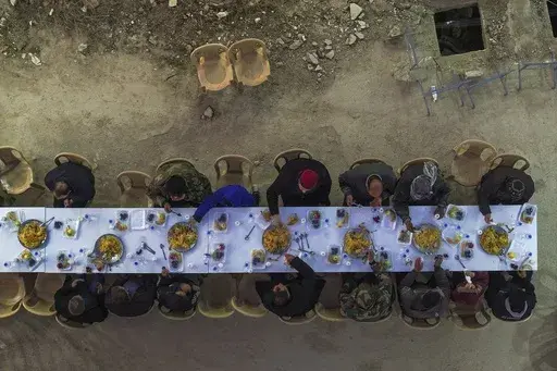Residents gather for iftar, the fast-breaking meal, organized by the Turkish Humanitarian Relief Foundation (IHH), on the first day of Ramadan in the Jobar neighborhood, which was devastated by the Syrian war, in Damascus, Syria, on Saturday, March 1, 2025.(AP Photo/Ghaith Alsayed)