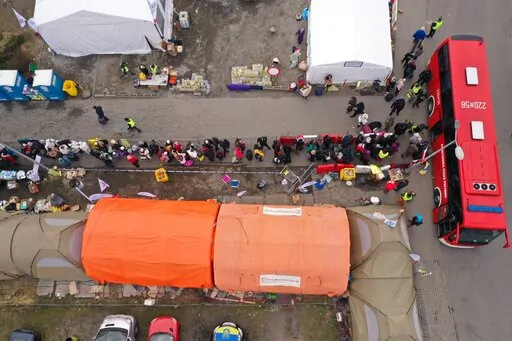 An aerial view of refugees queuing for transport at the border crossing at Medyka, Poland, Sunday March 13, 2022, where the main flow of Ukrainian refugees cross into Poland. The U.N. refugee agency says more than 2.5 million people, including more than a million children, have already fled Ukraine. It has become an unprecedented humanitarian crisis in Europe and the fastest refugee exodus since World War II. (AP Photo)