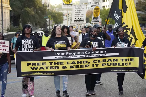 Jackson residents and supporters hold signs as they march to the Governor's Mansion in Jackson, Miss., to protest the ongoing water issues, poverty and other social ills, in the city, Oct. 10, 2022. A federal judge on Thursday, June 29, 2023, temporarily blocked a new Mississippi law that requires people to get permission from state police before having protests or other gatherings near state government buildings in Jackson. (AP Photo/Rogelio V. Solis, File)