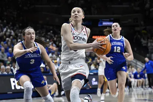 UConn guard Paige Bueckers, center, drives to the basket as South Dakota State guard Madison Mathiowetz, left, defends during the second half of a second round of the NCAA college basketball tournament, Monday, March 24, 2025, in Storrs, Conn. (AP Photo/Jessica Hill)