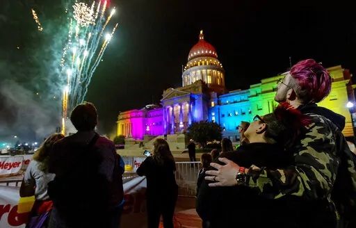 Fireworks shoot into the air next to the Idaho State House, which is illuminated in rainbow colors for the Boise Pride Festival on Friday, Sept. 9, 2022. The event continues through Sunday. (Sarah A. Miller/Idaho Statesman via AP)