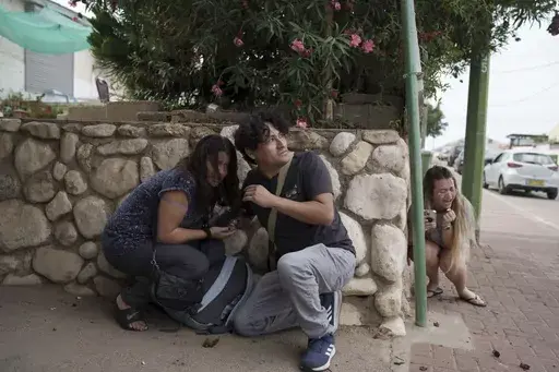 Israelis take cover from the incoming rocket fire from the Gaza Strip in Ashkelon, southern Israel on Oct. 11, 2023. (AP Photo/Leo Correa, File)