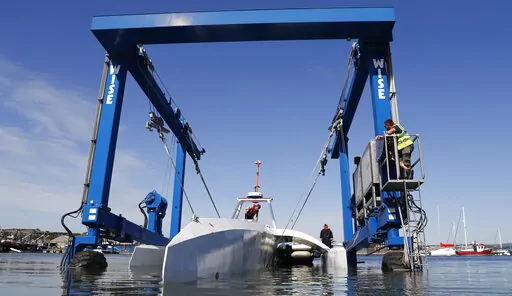 Technicians lower the Mayflower Autonomous Ship into the water at its launch site on Sept. 14, 2020, for its first outing on water since being built in Turnchapel, Plymouth south west England. The sleek autonomous trimaran docked in Halifax, Nova Scotia on Sunday, June 5, 2022, after more than five weeks crossing the Atlantic Ocean from England, according to tech company IBM, which helped build it. (AP Photo/Alastair Grant, File)