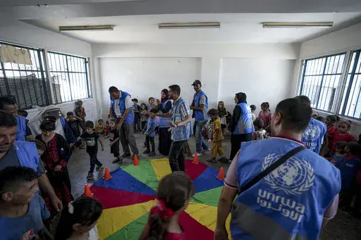 Palestinian children displaced by the Israeli air and ground offensive on the Gaza Strip take part in an entertaining activity organised by local activists, at a United-Nation run school, in Khan Younis, southern Gaza Strip, Wednesday, June 26, 2024. Hundreds of thousands of Palestinians in Gaza are struggling to maintain their mental health with few resources and no safe places to recover after nine months of war. (AP Photo/Abdel Kareem Hana)