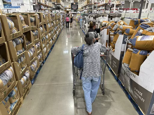 Shoppers look over blankets on sale in a Costco warehouse on Aug. 24, 2023, in Sheridan, Colo. On Thursday, the Commerce Department issues its first of three estimates of how the U.S. economy performed in the third quarter of 2023. (AP Photo/David Zalubowski, File)