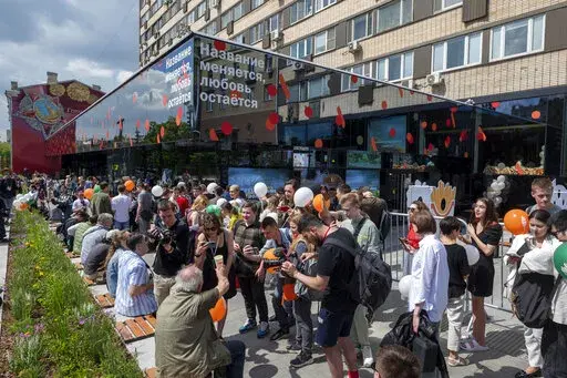 People lineup to visit a newly opened fast food restaurant in a former McDonald's outlet in Bolshaya Bronnaya Street in Moscow, Russia, Sunday, June 12, 2022. The sign reads 'The Name Changes, Love Remains'. The first of former McDonald's restaurants is reopened with new branding in Moscow. The corporation sold its branches in Russia to one of its local licensees after Russia sent tens of thousands of troops into Ukraine. (AP Photo/Dmitry Serebryakov)
