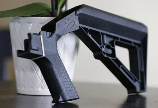 In this March 15, 2019, file photo, a bump stock is displayed in Harrisonburg, Va. A legal challenge to the Trump administration’s ban on bump stocks — devices attached to semiautomatic firearms so that a shooter can fire multiple rounds with a single trigger pull — was revived Thursday, June 23, 2022 by a federal appeals court. (AP Photo/Steve Helber, File)