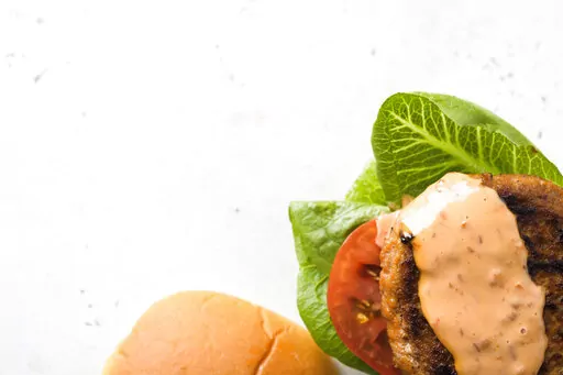 This image released by Milk Street shows a recipe for Smoky Chili-Garlic Pork Burgers. (Milk Street via AP)