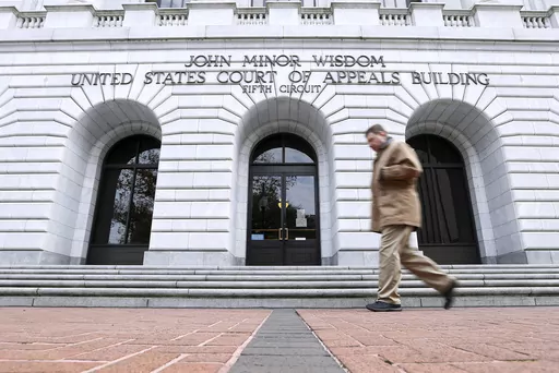 A man walks in front of the 5th U.S. Circuit Court of Appeals, Jan. 7, 2015, in New Orleans. The federal appeals court has temporarily delayed Mississippi officials from creating a state-run court in part of the majority-Black capital city of Jackson, Miss., even though a federal district court judge dismissed requests to block the new court in a ruling filed late Sunday, Dec. 31, 2023. (AP Photo/Jonathan Bachman, File)