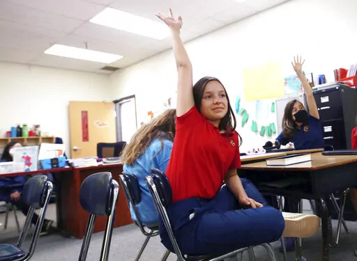 Lilianna Naizer-Baldwin,10, foreground center, raises her hand during her Spanish class at the New Mexico International School in Albuquerque, N.M., on Friday, May 27, 2022. Mary Baldwin a psychology intern at UNM Hospital Health science Center immigrated to the U.S. form Honduras when she was 10. Now her daughter Lilianna is the same age, and thanks to the dual language program she's fluent enough to cook banana-leaf-wrapped tamales with her Spanish-speaking grandmother. New Mexico is the only 