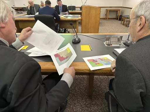 North Dakota state Rep. Robin Weisz, at left, and state Sen. Jerry Klein, both Republicans, inspect alternative maps proposed by the Turtle Mountain Band of Chippewa Indians and the Spirit Lake Tribe, on Tuesday, Dec. 5, 2023, during a meeting of a top legislative panel at the state Capitol in Bismarck, N.D. The 8th U.S. Circuit Court of Appeals denied a request on Friday, Dec. 15, to delay a federal judge's decision that North Dakota's legislative map violates the Voting Rights Act in diluting 