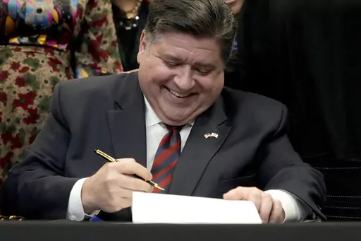 Illinois Gov. J.B. Pritzker signs into law the Paid Leave For All Workers Act on Monday, March 13, 2023, in Chicago. Illinois became one of three U.S. states to require employers to offer paid time off for any reason starting in January of 2024. (AP Photo/Charles Rex Arbogast)