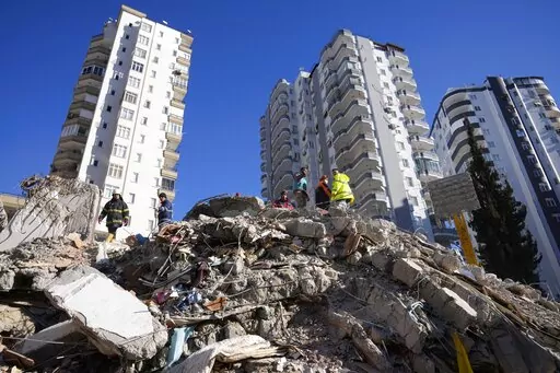 Emergency teams search for people in the rubble of a destroyed building in Adana, southern Turkey, Tuesday, Feb. 7, 2023. The 2011 quake, tsunami and nuclear meltdown in northern Japan provides a glimpse of what Turkey and Syria could face in the years ahead. No two events are alike, but the recent disaster resembles Japan's in the sheer enormity of the psychological trauma, of the loss of life and of the material destruction. (AP Photo/Hussein Malla, File)