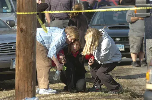People are comforted near Sandy Hook Elementary School, Dec. 14, 2012 in Newtown, Conn. Conspiracy theorist Alex Jones is seeking court permission to convert his personal bankruptcy reorganization to a liquidation, which would lead to a sell-off of a large portion of his assets to help pay some of the $1.5 billion he owes relatives of victims of the Sandy Hook Elementary School shooting. (AP Photo/Hearst Connecticut Media, Alex von Kleydorff via AP, File)