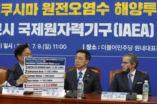 Main opposition Democratic Party lawmaker Woo Won-shik, left, shows a list of proposed disposal methods for the Fukushima contaminated water as his party lawmaker Wi Seong-gon and Rafael Mariano Grossi, Director General of the International Atomic Energy Agency, right, look on during a meeting with the party's lawmakers at the National Assembly in Seoul, South Korea, Sunday, July 9, 2023. (AP Photo/Ahn Young-joon)