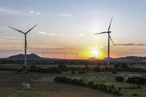 The sun sets behind a windmill farm in Anantapur district, Andhra Pradesh, India, Sept 14, 2022. India officially takes up its role as chair of the Group of 20 leading economies for the coming year Thursday, Dec. 1 and it's putting climate at the top of the group's priorities. (AP Photo/Rafiq Maqbool, File)