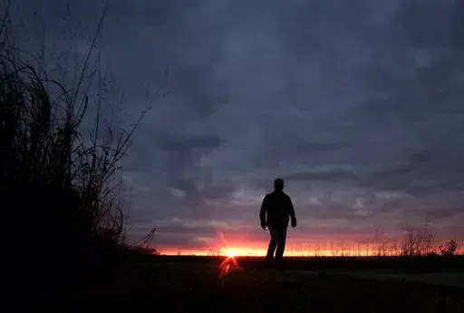 In this Nov. 20, 2015 file photo, a man walks along a trail during sunset near Manhattan, Kan. In 2022, about 49,500 people took their own lives in the U.S., the highest number ever, according to data from the Centers for Disease Control and Prevention released on Thursday, Aug. 10, 2023. (AP Photo/Charlie Riedel, File)
