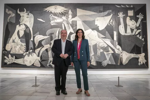 French Culture Minister Rima Abdul-Malakin, right, poses for a picture next to his Spanish counterpart Miquel Iceta during a joint news conference in front of Pablo Picasso's "Guernica" painting to present the "Picasso Year" events, marking the 50th anniversary of the painter's death, at the Reina Sofia Museum in Madrid, Spain, Monday, Sept. 12, 2022. Against the backdrop of Picasso's iconic anti-war painting, "Guernica," the culture ministers of France and Spain have gathered in Madrid to kick 